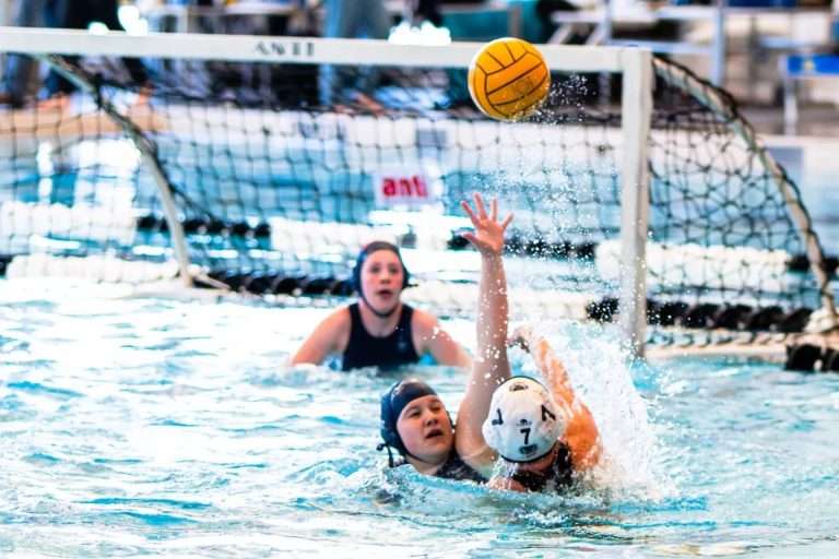 three girls throwing the ball into the goal waterpolo 1hafj